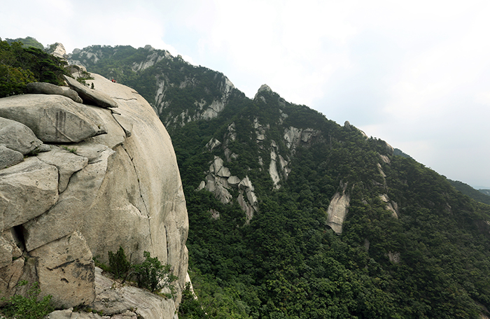 Hikers in the distance sit on the rock to rest and to enjoy the breeze while climbing the Hidden Wall trail of Bukhansan Mountain on July 31. (photo: Jeon Han)