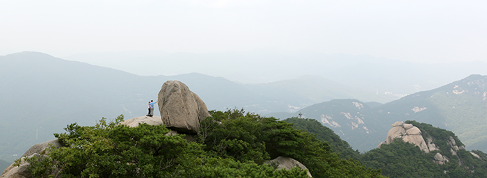 Hikers take a photo with the Hidden Wall of Bukhansan Mountain in the background, on July 31. (photo: Jeon Han)