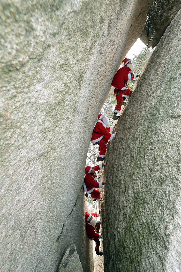 Clad as Santa Claus, rescuers climb the Haegolbawi, ''Skeleton Rock,'' of Bukhansan Mountain on December 21, four days before Christmas. They remind us of Santa Claus as he climbs up the chimney to bring Christmas gifts.