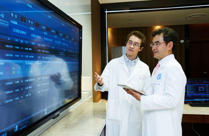Patients and doctors discuss medical records while looking at the HIS. 