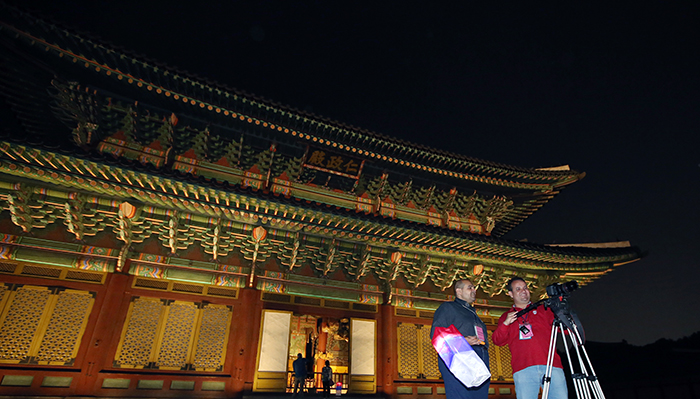 A camera crew shoots some night footage of Seoul in front of Changdeokgung Palace's Injeongjeon Hall on April 30.