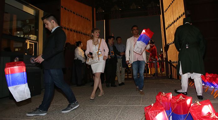 Journalists participating in the Moonlight Tour receive their traditional <i>cheognsachorong</i> lanterns as they pass through the Donhwamun Gate on April 30.