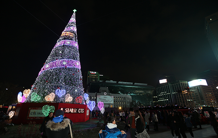 On November 30, citizens collect holiday memories at the giant Christmas tree in the square in front of Seoul City Hall, taking pictures of loved ones and themselves against the festive backdrop. (photo: Jeon Han)