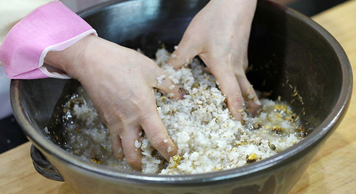 Add water and mix it all gently together with your hands. Make sure to not damage the rice in order to get a clear liquor.