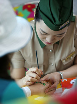 A car attendant paints the hand of a passenger on the new DMZ Gyeongwon train. (photo: Jeon Han)
