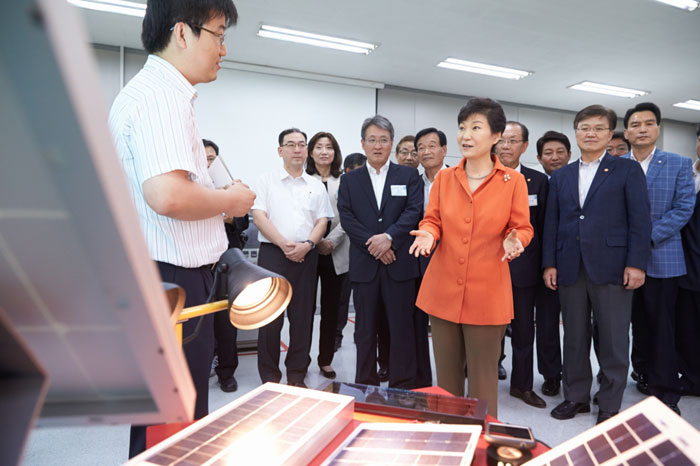 President Park Geun-hye listens to an explanation about solar energy modules and power generation devices from a student of Yeungjin College in Daegu.