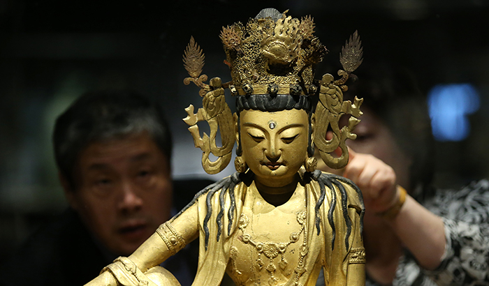 Visitors admire the 'Avalokiteshvara Bodhisattva and Bokjangmul' produced in the 13th century during Goryeo times, during a press opening for the 'Devout Patrons of Buddhist Art' exhibit, at the National Museum of Korea on May 22.