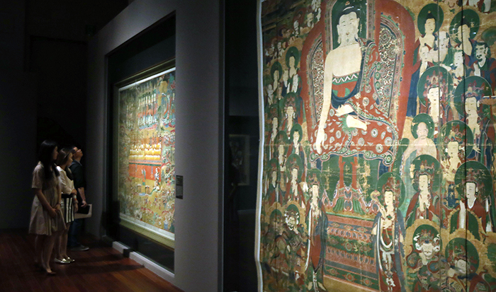 Visitors admire the 'Saving Hungry Ghosts by Giving Nectar' painting produced during Joseon times in 1764, part of the 'Devout Patrons of Buddhist Art' exhibit going on at the National Museum of Korea, on May 22. The painting on the right is the 'Shakyamuni's Preaching at Vulture Peak' painting, made in 1777 during Joseon times.