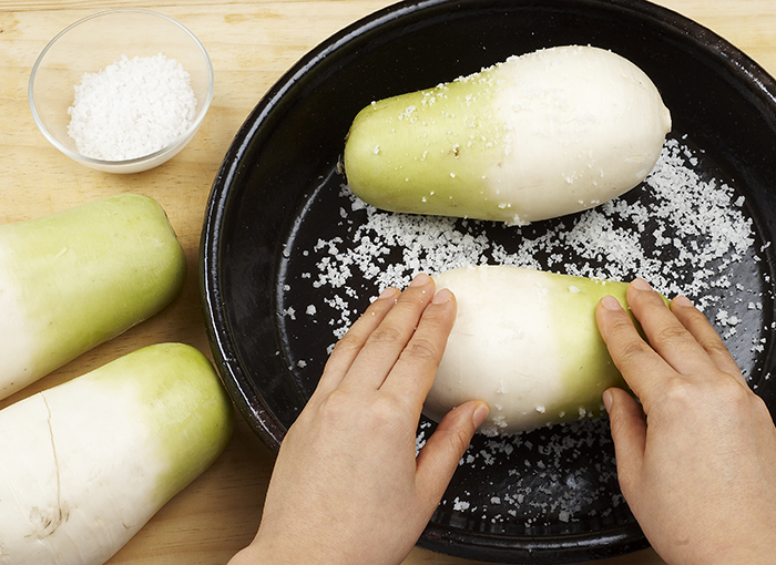 Trim and wash the white radish. Rub it with rock salt to clean. Salt the white radish for two days.