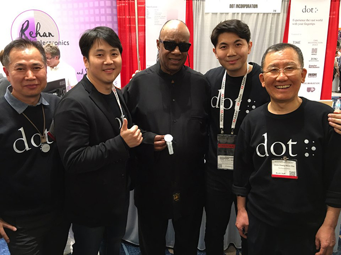 Stevie Wonder (center) poses with Dot co-founder Kim Ju Yoon (second from left) and other Dot employees. Stevie Wonder visited Dot’s booth at the CSUN Conference 2016 in March last year and showed strong interest in the Dot Watch, praising its features.