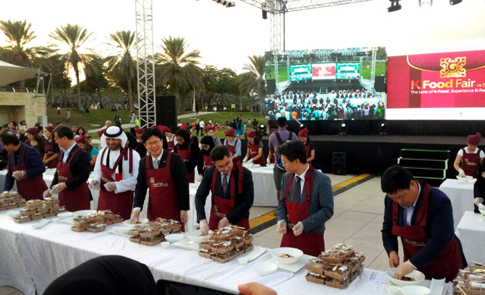 Representatives from the Korean and UAE governments prepare halal Korean food at the Korean food fair on Nov. 27 in Dubai.