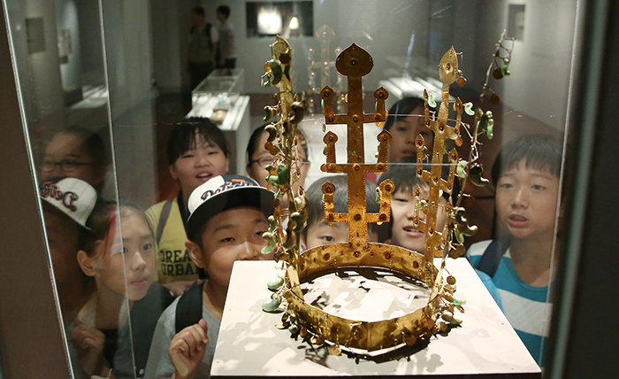 Young museum goers admire a golden crown from the Silla Kingdom, a relic discovered at the Geumgwanchong Tomb in Gyeongju, the then capital of the ancient kingdom, at the National Museum of Korea. (photo: Jeon Han)