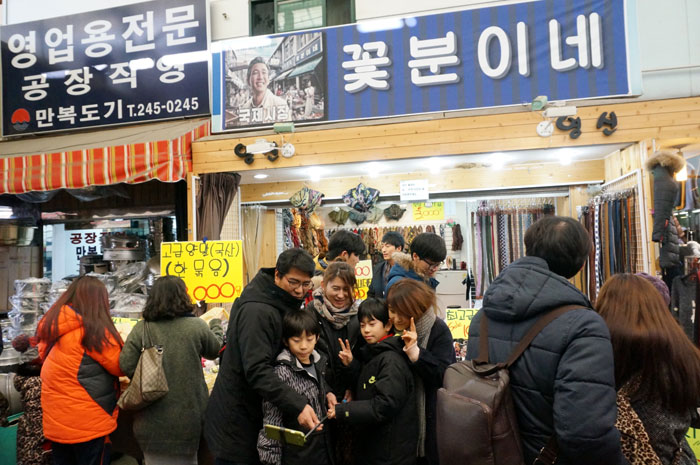 People take selfies in front of <i>Kkobbunine</i>, the shop which the character Deoksu runs in the movie 'Ode to My Father.' Much of the movie was filmed in and around Gukje Market in Busan.