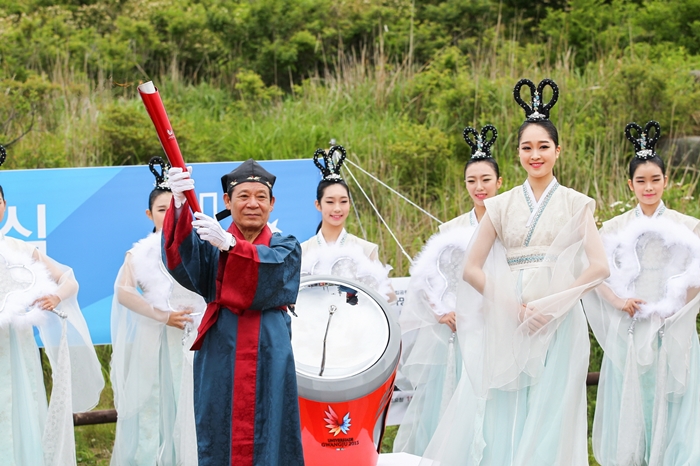 Gwangju Universiade Organizing Committee President Yoon Jang-hyun holds up the lit torch for the Gwangju Summer Universiade Games at the Jangbuljae mountain pass at Mudeungsan National Park.