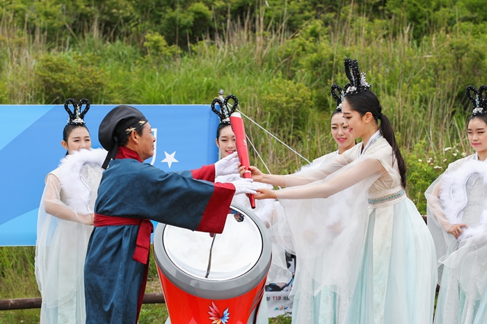 Gwangju Universiade Organizing Committee President Yoon Jang-hyun holds up the lit torch for the Gwangju Summer Universiade Games at the Jangbuljae mountain pass at Mudeungsan National Park.