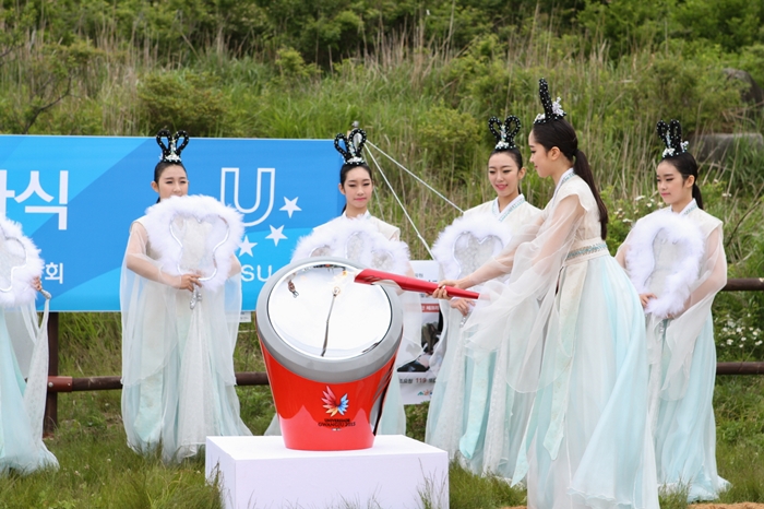 Students from Gwangju Arts High School light the torch for the Gwangju Summer Universiade Games at the Jangbuljae mountain pass at Mudeungsan National Park.