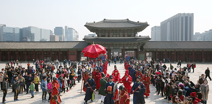 Tourists at Gyeongbokgung Palace watch the march of the king during the appointment ceremony for the royal gatekeepers in front of the Geunjeongjeon Hall on Mar. 27.
