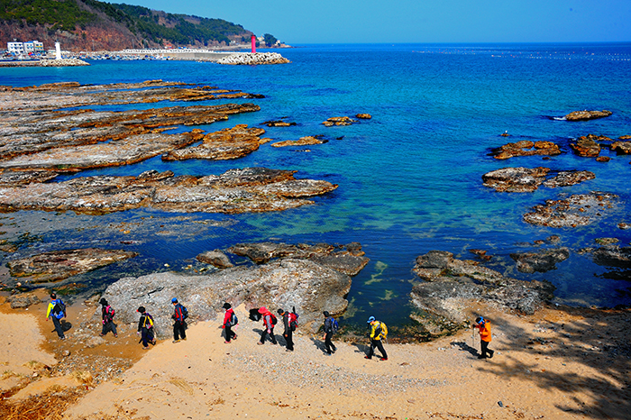 Intrepid adventurers enjoy the scenic view from the beach as they walk along Course No. 21 in the Yeongdeok section of the Haeparang Trail.