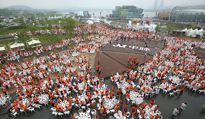 A 4,000-strong group of employees from the Chinese healthcare company Nanjing Joymain Science & Technology gathers at the Banpo Hangang River Park in Seoul to enjoy a <i>samgyetang</i> dinner on May 6.
