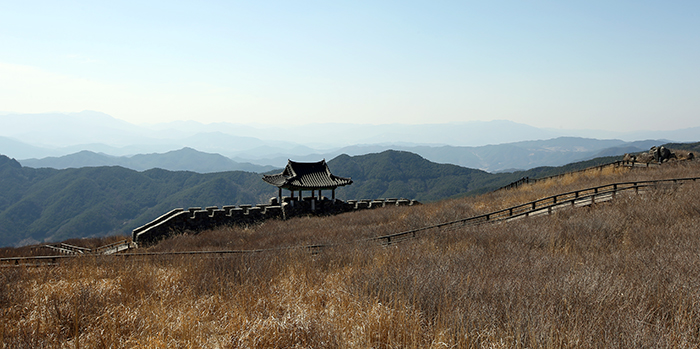  A fortress wall and a watchtower sit on the grassy hill. Both were used as sets for a historical soap opera. 