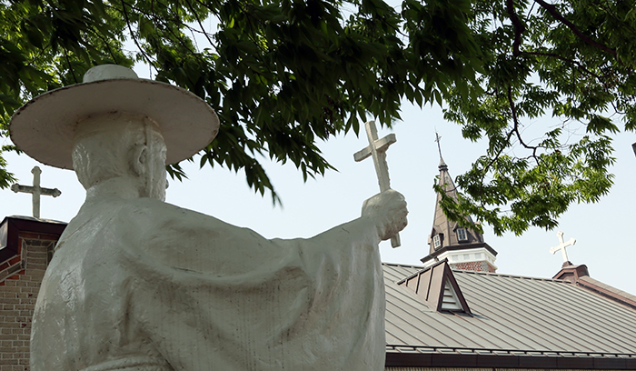  (Top) A painting of the Holy Family donated by a cousin of Father Philippe Perrin. (Bottom) A statue of St. Andrew Kim Dae-geon near the Hapdeok Catholic Church. (photos: Jeon Han) 