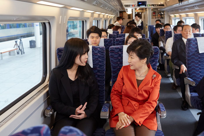 President Park Geun-hye (right) talks with a passenger on the newly inaugurated Honam High-Speed Railway.