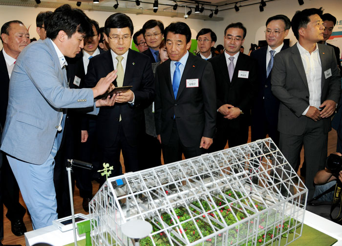 Participants in the center's opening ceremony examine a miniature smart farm at the Sejong Center for a Creative Economy and Innovation on June 30.