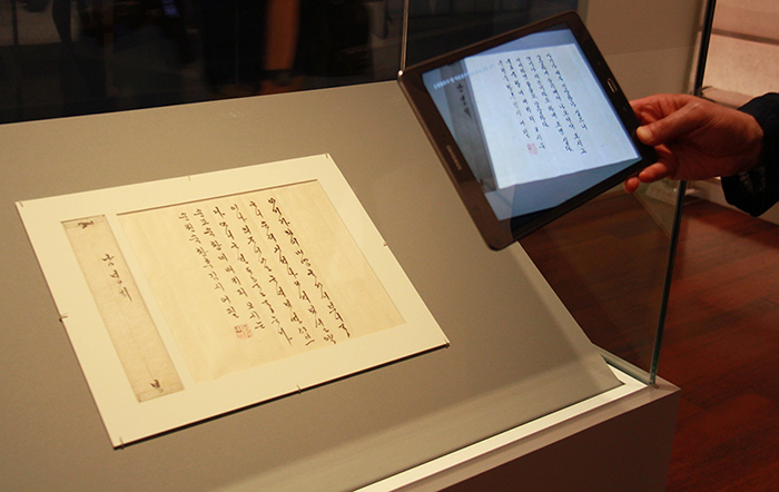 Museum-goers can learn more about the historical documents by using AR audio-visual facilities, such as tablet PCs. The photo shows visitors reading Queen Sunwon’s letters using a tablet.