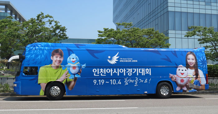 A bus is decorated with photos of swimmer Park Tae-hwan (left) and rhythmic gymnast Son Yeon-jae. They are PR ambassadors for the Incheon Asian Games 2014. (photo courtesy of the Incheon Asian Games Organizing Committee)
