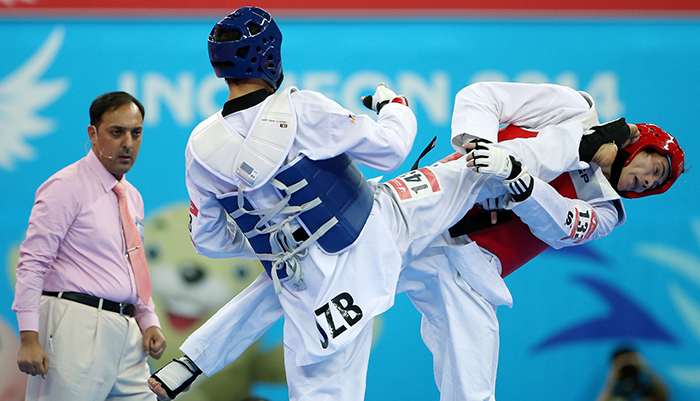 Baykuziev Jasur (left) kicks Chen Linglong in the face during the gold medal match in the men’s taekwondo 87 kilogram event on September 30 in Incheon.