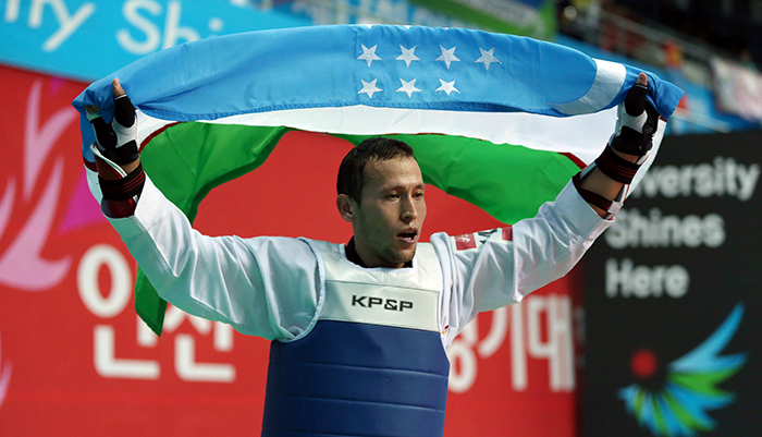 Baykuziev Jasur of Uzbekistan celebrates his victory with the Uzbekistani national flag after winning the men’s taekwondo 87 kilogram event on September 30 in Incheon.