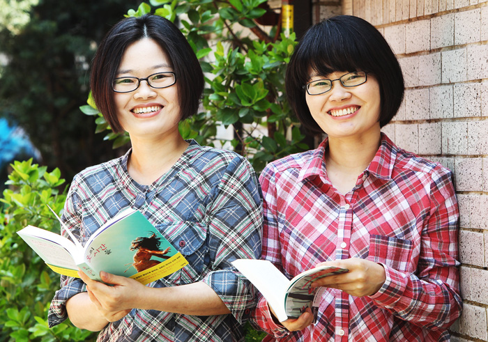 Writer Jang Eun-jin (right) poses with her twin sister Kim Hee-jin, also a novelist. They are called the “twin novelists.” (photo: Yonhap News)