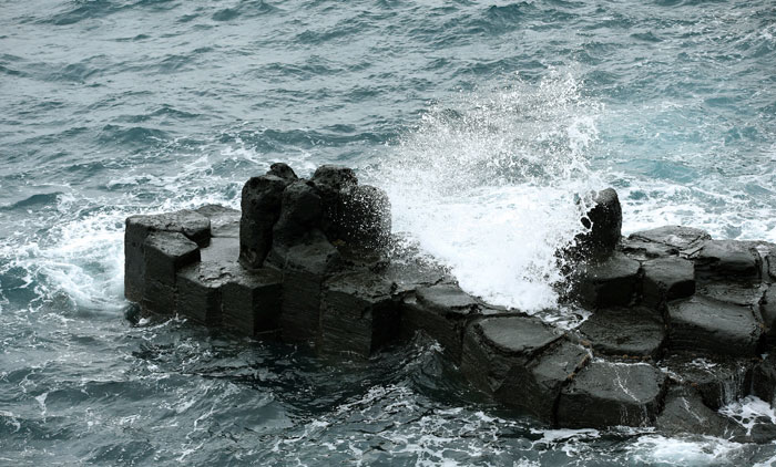 The columnar joints of the Jusangjeolli Cliffs at the Jungmun Tourism Complex can be seen on Jejudo Island. These columnar joints are created by basaltic lava flow.