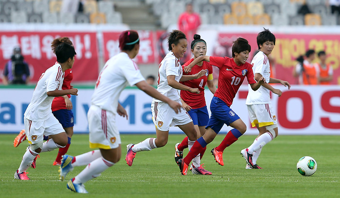 Ji So-yun, No. 10, dribbles past Chinese defenders in a match against China during the East Asian Cup of the East Asian Football Federation in July 2013. (photo: Yonhap News)