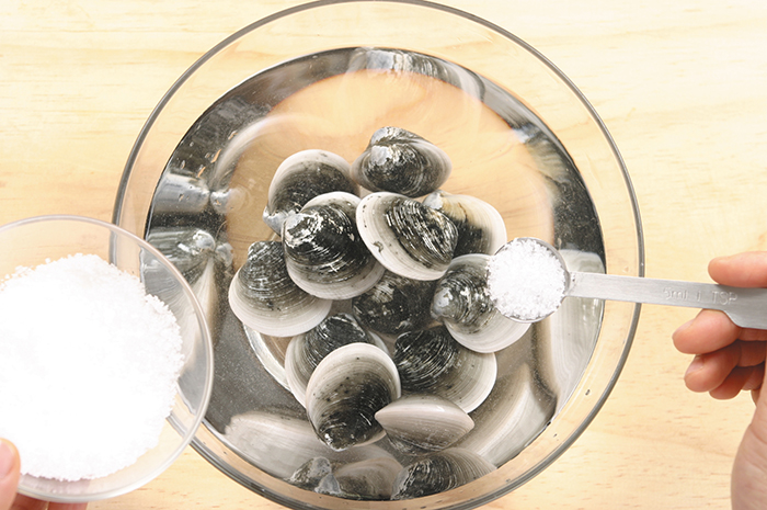 Wash, clean and trim the clams. Put them in salt water for 3 hours so that the clams will spit out any watery sediment that may remain inside.