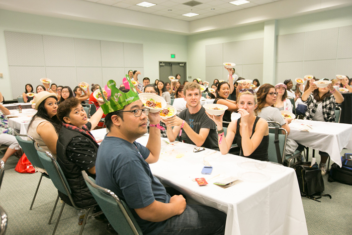 Participants in a Korean cooking class hold up their bowls of bibimbap. 