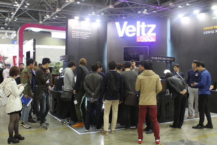 At the LG Innotek booth (top), visitors can see a module for a camera with an optical image stabilizer (OIS) and 20.7 million pixels. At the Veltz booth (bottom), fair-goers can see the company's new 3-D printing technology. 