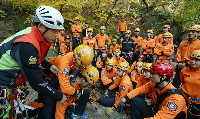 Park Yong-hwan (left), manager at the National Park School of Mountaineering Safety, gives a lecture on how to safely move a wounded hiker. He's speaking to Gyeonggi Fire Service Academy students, on October 29. 