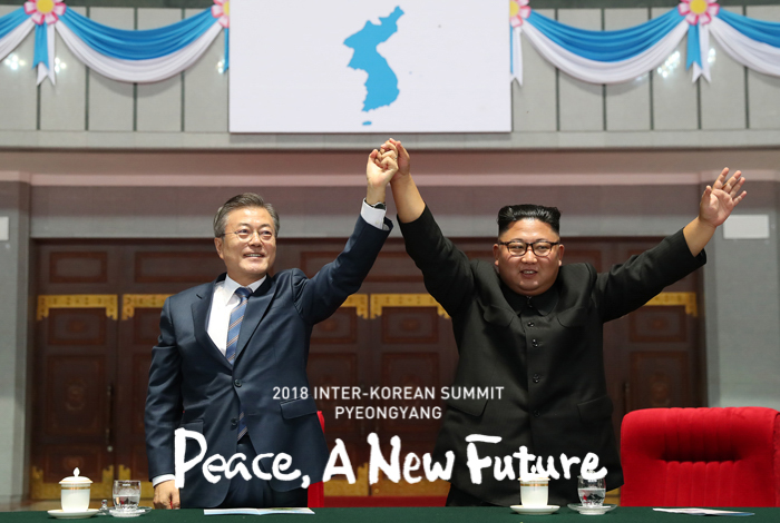 President Moon Jae-in (left) and North Korean leader Kim Jong Un raise their hands together to the audience after watching a mass gymnastics performance "Brilliant Fatherland" at the May Day Stadium in Pyeongyang. (Pyeongyang Press Corps)