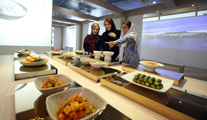 A group of Iranian university students check out the kimchi on display at the K-Culture Exhibit at the Milad Tower in Tehran on May 2. A range of kimchi was on display, including varieties that used tomatoes, onions and pomegranates.
