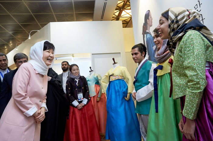 President Park Geun-hye (left) talks with Iranian youth who are wearing traditional Korean Hanbok attire at the K-Culture Exhibit in Tehran on May 2. 