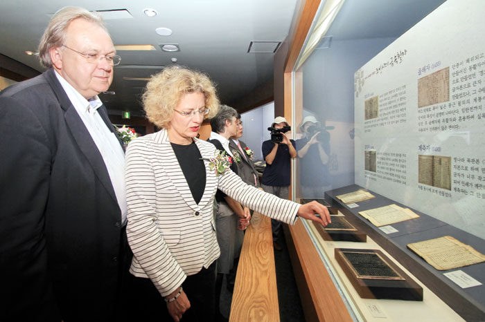 Visitors to an exhibition admire the metal type printing blocks.