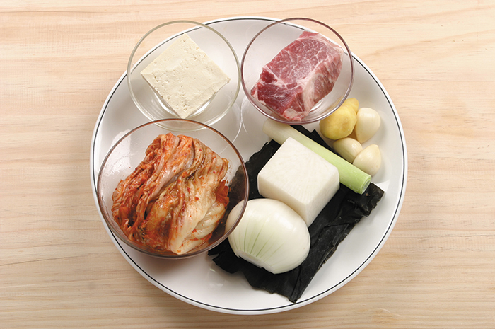 The main ingredients for kimchi stew are cabbage kimchi, pork, tofu, onions, garlic, ginger and kelp.