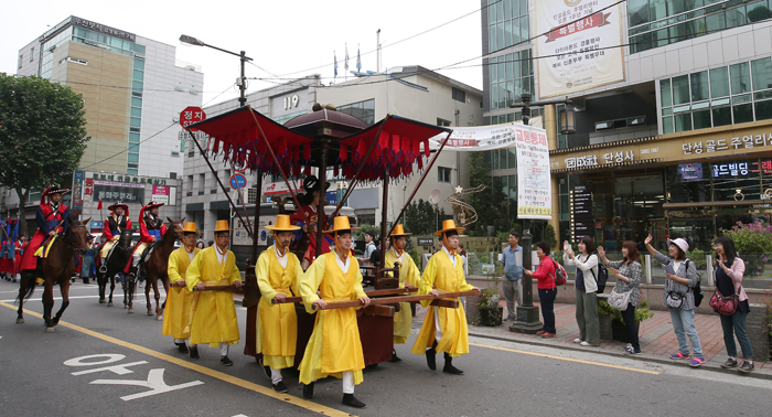 Japanese tourist Sidara Hiromi (設樂诰美) (second from right), visiting Korea to see the 2017 King Jeongjo Tomb Parade, waves to Lady Hyegyeong’s palanquin as it passes exit No. 9 of Jongno 3-ga Station, in Seoul on Sept. 23.