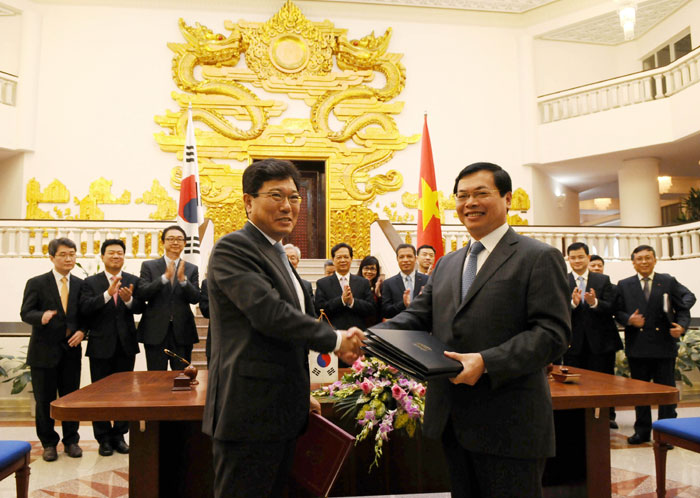 Minister of Trade, Industry and Energy Yoon Sang-jick (left) and Vietnam's Minister of Industry and Trade Vu Huy Hoang shake hands after signing a free trade agreement between Korea and Vietnam, in Hanoi on May 5.