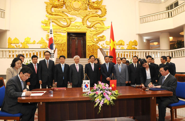 Minister of Trade, Industry and Energy Yoon Sang-jick (seated, left) and Vietnam's Minister of Industry and Trade Vu Huy Hoang sign the FTA documents on May 5 in Hanoi, with Vietnamese Prime Minister Nguyễn Tấn Dũng in attendance.
