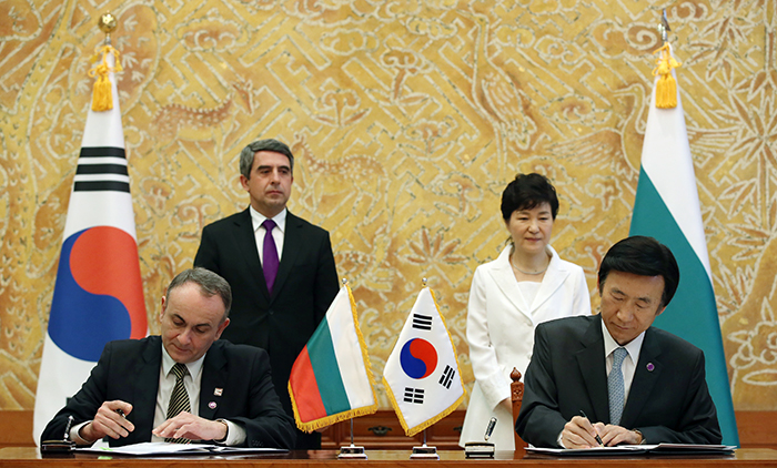 Minister of Foreign Affairs Yun Byung-se (right) and Valentin Poriazov, the Bulgarian deputy minister of foreign affairs, sign an agreement to cooperate on education and the arts, on May 14 in Seoul. The signing ceremony is attended by President Park Geun-hye (back, right) and her Bulgarian counterpart, Rosen Plevneliev.