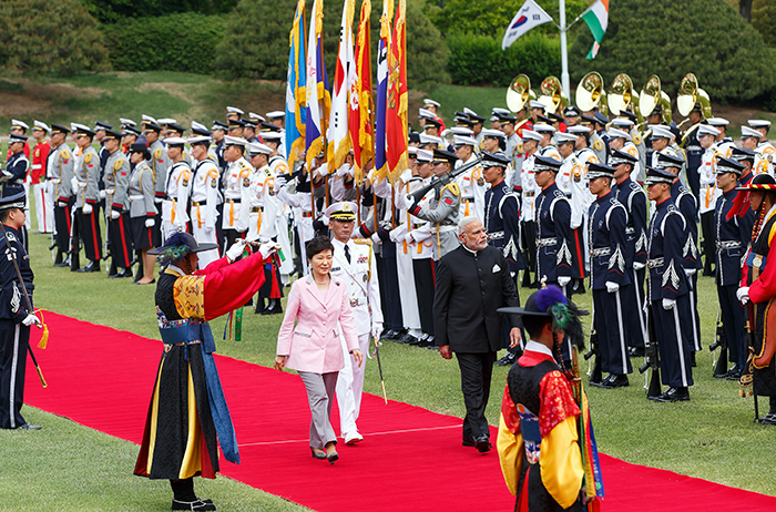 President Park Geun-hye (middle, left) and Indian Prime Minister Narendra Modi walk side by side in the Daejeongwon Garden of Cheong Wa Dae during the official welcoming ceremony for his state visit on May 18, as honor guards line the red carpet. .