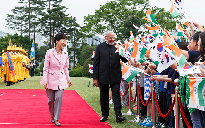 President Park Geun-hye (left) and Indian Prime Minister Narendra Modi greet children who wave national flags of the two nations during the official welcoming ceremony on May 18..