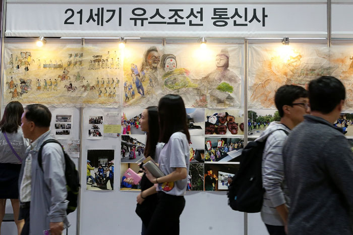 Visitors look around tourism promotional booths for Korea and Japan at the festival.